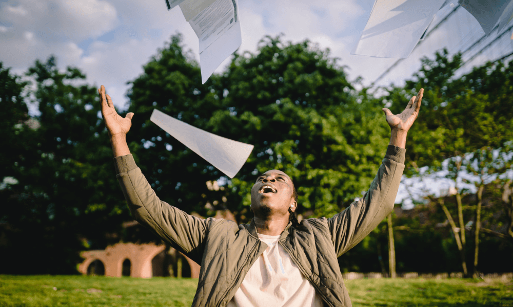 Happy man throwing papers in the air