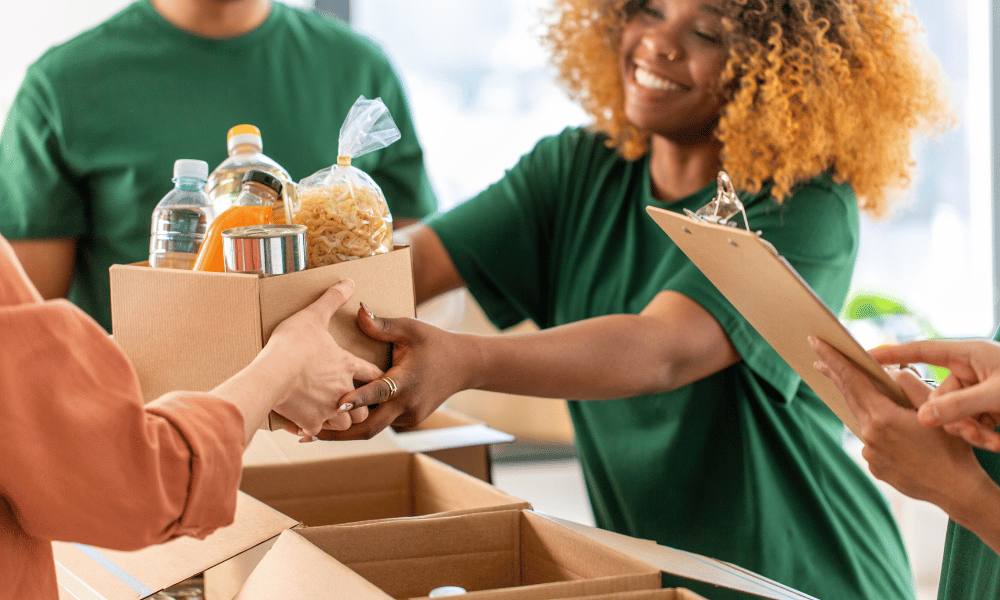 Volunteer handing a box of food to community member in need