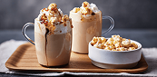 Two popcorn-topped lattes with whipped cream