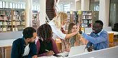 Teacher high-fiving college students in a library