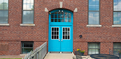 Bright turquoise doors on brick school entrance